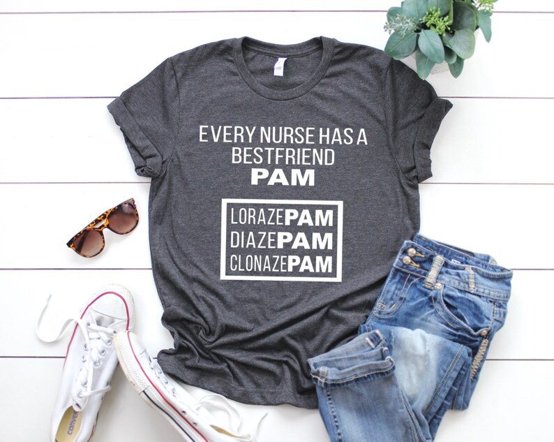 May include: A dark gray t-shirt with the text "Every nurse has a best friend PAM" and a box with the text "Lorazepam, Diazepam, Clonazepam" in white lettering.