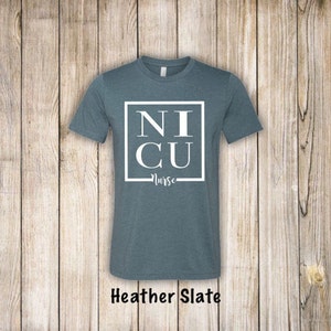 May include: A heather slate blue t-shirt with a white square graphic that says "NICU Nurse".