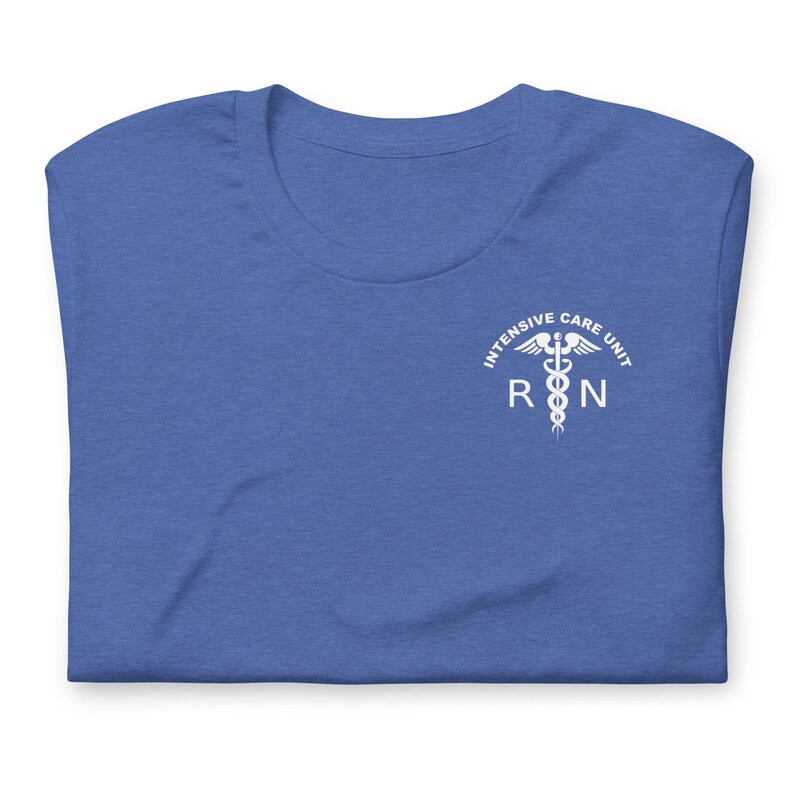 Folded heather royal blue ICU nurse shirt with white critical care RN chest design.
