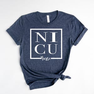 May include: A navy blue t-shirt with a white square graphic that says "NICU Nurse" in a bold font.