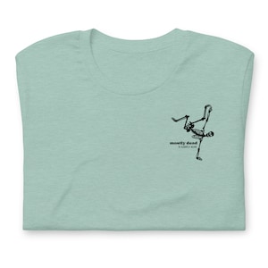 Puede incluir: Una camiseta azul claro con un gr&aacute;fico de esqueleto negro haciendo un movimiento de breakdance. El texto "mostly dead is slightly alive" est&aacute; impreso debajo del esqueleto.
