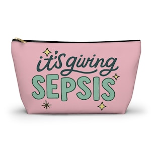 May include: A pink zippered pouch with the text "it's giving SEPSIS" in teal and black lettering. The pouch has a gold zipper and black trim. Decorative stars are around the text.