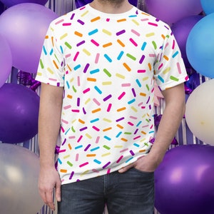 May include: A white t-shirt with a colorful sprinkle pattern. The shirt is made of a soft, comfortable material and is perfect for everyday wear.