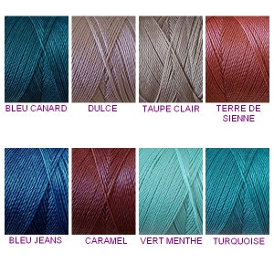 Peut inclure: Dix bobines de fil à broder de différentes couleurs, dont turquoise, beige, marron, bleu et vert. Le fil est disposé en deux rangées de cinq bobines chacune. Les noms des couleurs sont imprimés sous chaque bobine.