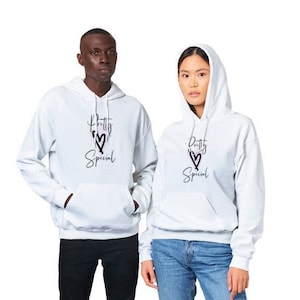 May include: Two people wearing grey hooded sweatshirts with the text "Pretty Special" and a heart graphic. The person on the left is wearing black pants and the person on the right is wearing blue jeans.