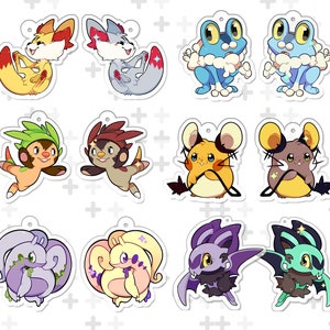 May include: Twelve cartoon character keyrings in various animal designs. The keyrings feature foxes, frogs, mice, and bats in bright colours. Each keyring has a small hole at the top for attachment.