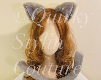 May include: Gray cat ears and tail headband. The ears are made of soft, fluffy fur and are attached to a headband. The tail is also made of soft fur and is attached to a clip. The headband and tail are both gray.