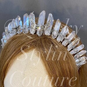 May include: A silver and crystal crown with a crescent moon and star design. The crown is made of wire and features clear quartz crystals.