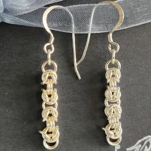 Pendants d'oreilles en argent sterling de style byzantin sur une carte de voeux imprimée à la main avec une enveloppe blanche.