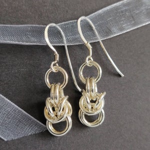 Orecchini pendenti in argento sterling in stile bizantino su un biglietto d'auguri stampato a mano e racchiuso in una busta bianca.