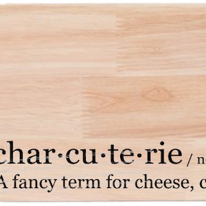 May include: A wooden cutting board with a handle, featuring the text "char-cu-te-rie / noun / shar koo ter ee A fancy term for cheese, crackers and stuff".
