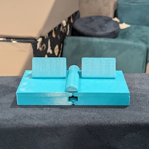 Peut inclure: Un canapé modulaire imprimé en 3D de couleur bleu turquoise avec deux accoudoirs et une section centrale. Le canapé est composé de plusieurs pièces qui peuvent être disposées dans différentes configurations.