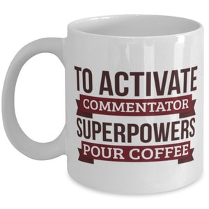May include: White ceramic coffee mug with the text "To activate commentator superpowers pour coffee" in brown lettering with red ribbon accents.