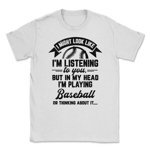 May include: White t-shirt with a black graphic that says "I might look like I'm listening to you, but in my head I'm playing Baseball or thinking about it..."