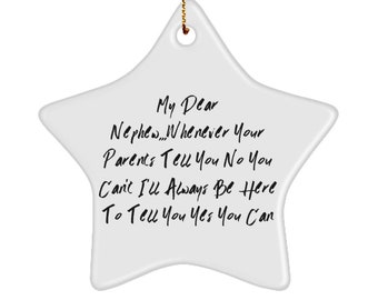 May include: A white star-shaped ornament with a gold string for hanging. The ornament has black handwritten text that reads, "My Dear Nephew...Whenever Your Parents Tell You No You Can't I'll Always Be Here To Tell You Yes You Can."