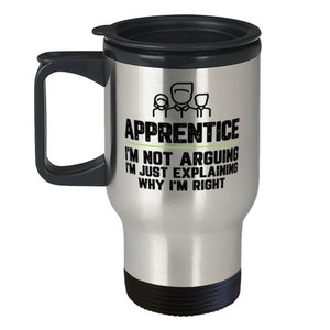 May include: A silver travel mug with a black lid and handle. The mug has a black graphic that says "Apprentice I'm not arguing I'm just explaining why I'm right".