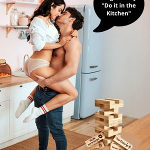 girl straddlingguy in kitchen in underwear with party blox game sitting on counter and caption saying that the game says do it in the kitchen player games for couples relationship gifts for boyfriend romantic card game couples edition lets fucking