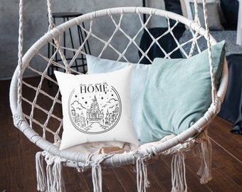 Puede incluir: Cojín blanco con texto negro que dice "There is no place like HOME" con una ilustración en blanco y negro de un castillo y estrellas en un círculo alrededor del texto.
