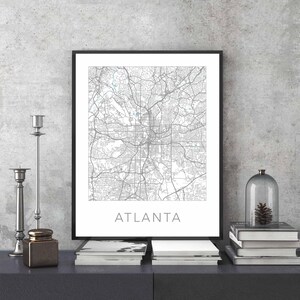 Pu&ograve; includere: Una stampa di mappa in bianco e nero di Atlanta, Georgia, in una cornice nera. La mappa &egrave; centrata sulla citt&agrave; e mostra le principali strade e vie. La parola "ATLANTA" &egrave; stampata in nero nella parte inferiore della stampa.
