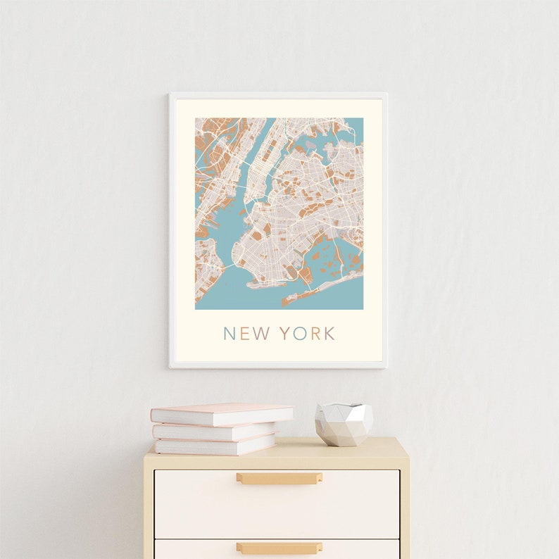 K&ouml;nnte beinhalten: Ein gerahmter Druck einer Karte von New York City mit hellblauem Hintergrund und braunen Linien. Der Text "NEW YORK" ist unter der Karte gedruckt.
