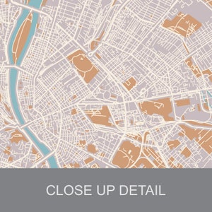 May include: A detailed map of a city with a river running through it. The map is in shades of brown, beige, and blue. The river is a light blue color and the streets are a light brown color. The map is a close-up of the city center.