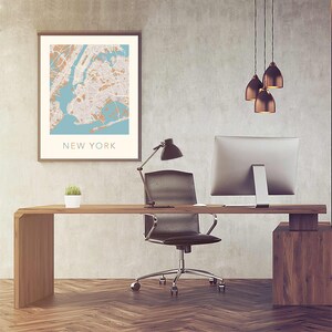K&ouml;nnte beinhalten: Ein modernes Heimb&uuml;ro mit einem Holzschreibtisch, einem schwarzen B&uuml;rostuhl, einem Computermonitor, einer Schreibtischlampe und einer gerahmten Karte von New York City. Drei Pendelleuchten h&auml;ngen von der Decke.
