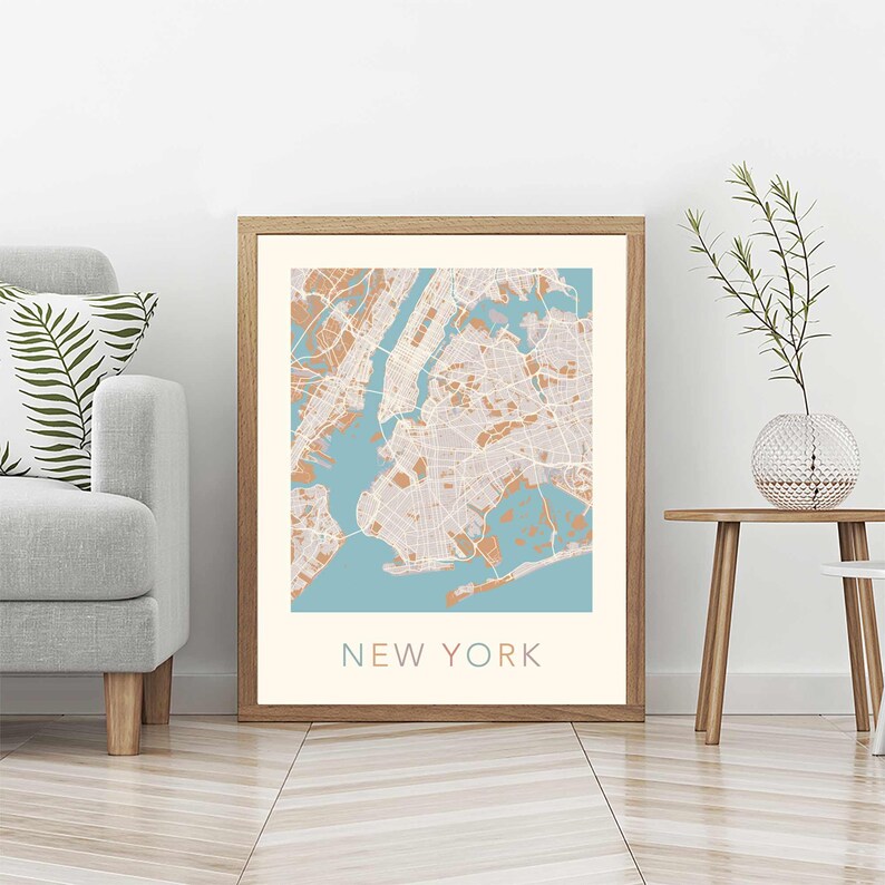 K&ouml;nnte beinhalten: Ein gerahmter Druck einer Karte von New York City mit hellblauem Hintergrund und braunen Linien. Der Text "NEW YORK" ist unten auf der Karte in Braun gedruckt.