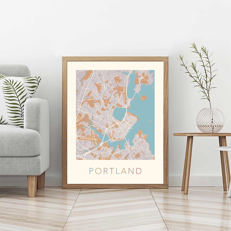 Pu&ograve; includere: Una stampa incorniciata di una mappa di Portland, Maine. La mappa &egrave; in una cornice marrone chiaro e ha uno sfondo blu chiaro con linee marroni che rappresentano le strade. La parola "PORTLAND" &egrave; stampata in un carattere colorato nella parte inferiore della mappa.