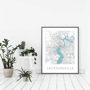 Pu&ograve; includere: Una stampa incorniciata nera di una mappa di Jacksonville, Florida. La mappa &egrave; in stile minimalista con linee grigie e un'area d'acqua blu chiaro. Il nome della citt&agrave; &egrave; stampato in nero nella parte inferiore della mappa.