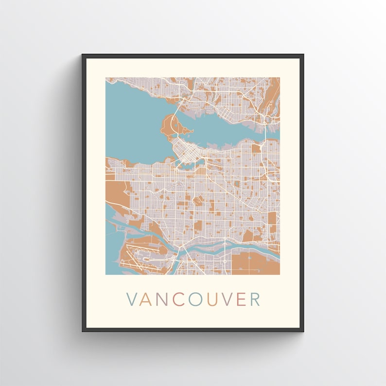 Op de afbeelding: Een ingelijste kaartprint van Vancouver, met een gedetailleerd stratenraster in tinten van bruin en wit, met blauwe en bruine waterelementen. Het woord "VANCOUVER" is in turquoise onderaan de print gedrukt.