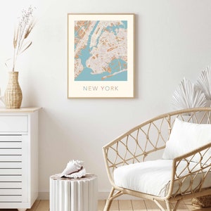 K&ouml;nnte beinhalten: Ein gerahmter Druck einer Karte von New York City mit hellblauem Hintergrund und braunen Linien. Der Text "NEW YORK" ist unter der Karte gedruckt.