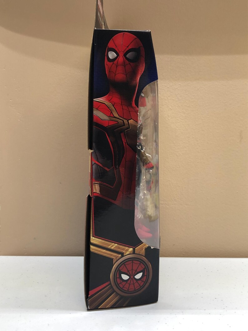 May include: A red and gold Spider-Man action figure in a box. The figure is wearing a red and gold suit with a black spider logo on the chest. The box has a picture of Spider-Man on the front.
