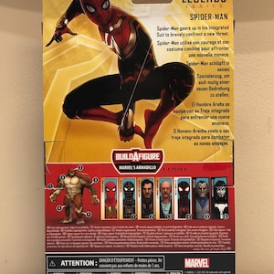 May include: A Marvel Legends Series Spider-Man action figure with a red and black suit. The figure is posed in a dynamic action pose. The packaging features a Build-A-Figure Marvel's Armadillo figure. The packaging also includes text in English, French, German, Spanish, and Portuguese.