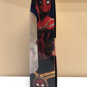 May include: A red and gold Spider-Man action figure in a box. The figure is wearing a red and gold suit with a black spider logo on the chest. The box has a picture of Spider-Man on the front and the Marvel logo on the back.