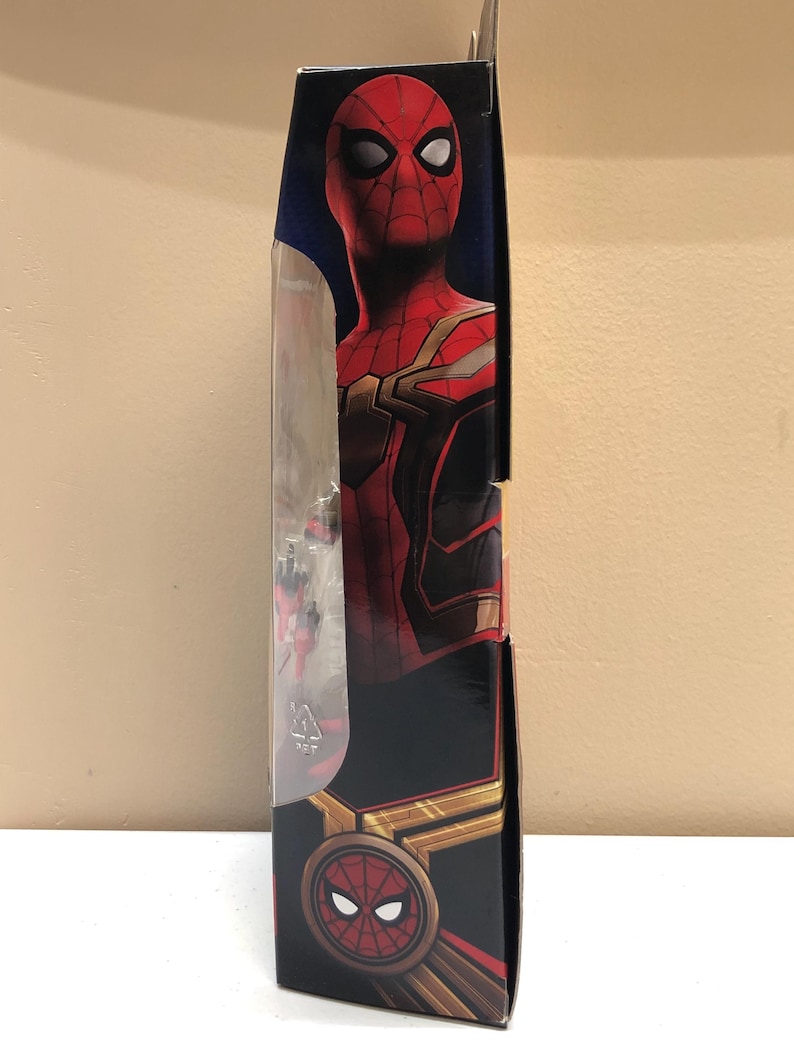 May include: A red and gold Spider-Man action figure in a box. The figure is wearing a red and gold suit with a black spider logo on the chest. The box has a picture of Spider-Man on the front and the Marvel logo on the back.