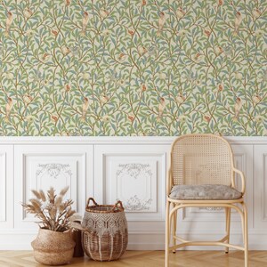 May include: A white wall with floral wallpaper featuring a repeating pattern of green leaves, red and yellow birds, and white flowers. A wicker chair with a light brown cushion sits in front of the wall. Two woven baskets are on the floor in front of the chair.