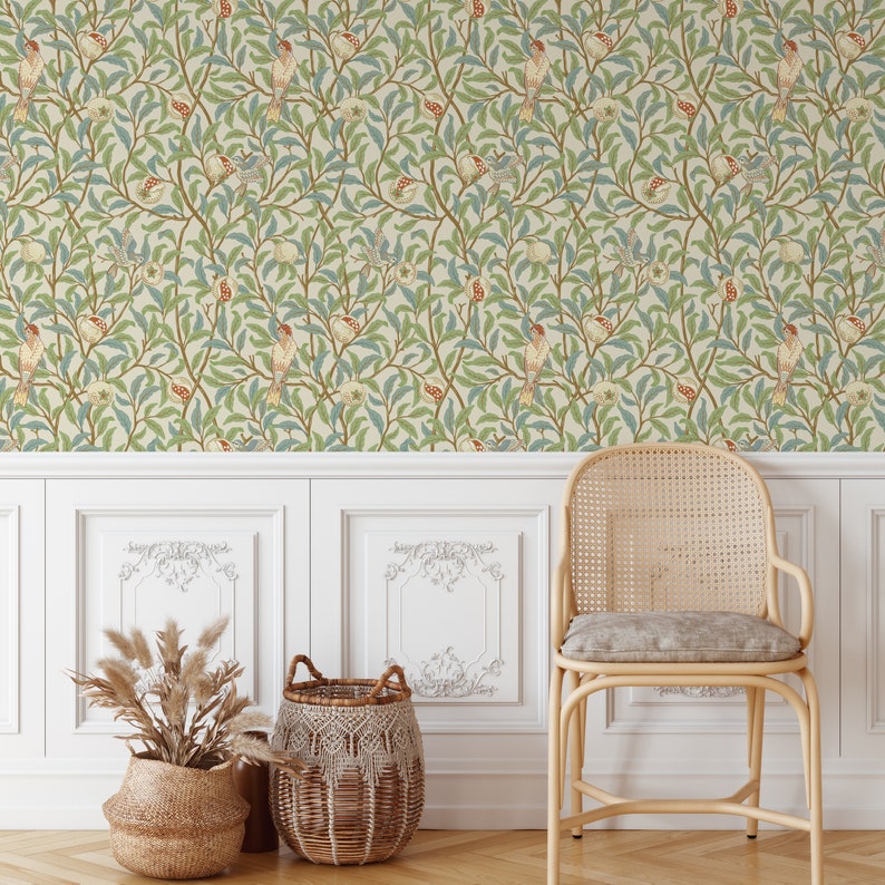 May include: A white wall with floral wallpaper featuring a repeating pattern of green leaves, red and yellow birds, and white flowers. A wicker chair with a light brown cushion sits in front of the wall. Two woven baskets are on the floor in front of the chair.