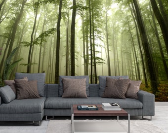 May include: A gray sectional sofa with brown throw pillows sits in front of a wall mural depicting a misty forest with tall trees.