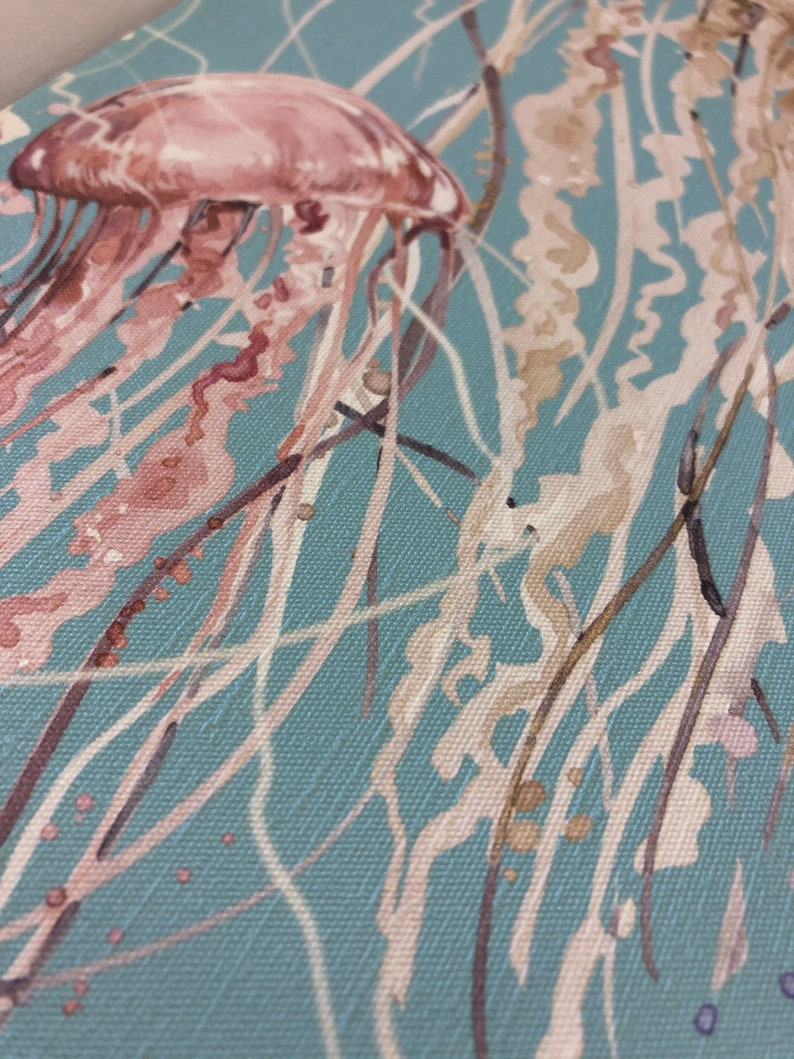 May include: A watercolor painting of a pink jellyfish with long tentacles against a blue background.