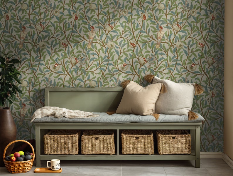 May include: A green bench with a cushion and four woven baskets underneath. The wall behind the bench is covered in wallpaper with a floral pattern featuring birds and pomegranates.