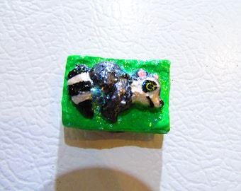 Refrigerator Magnet of A Phabrisaur Raccoon with A Green Background, July 2025