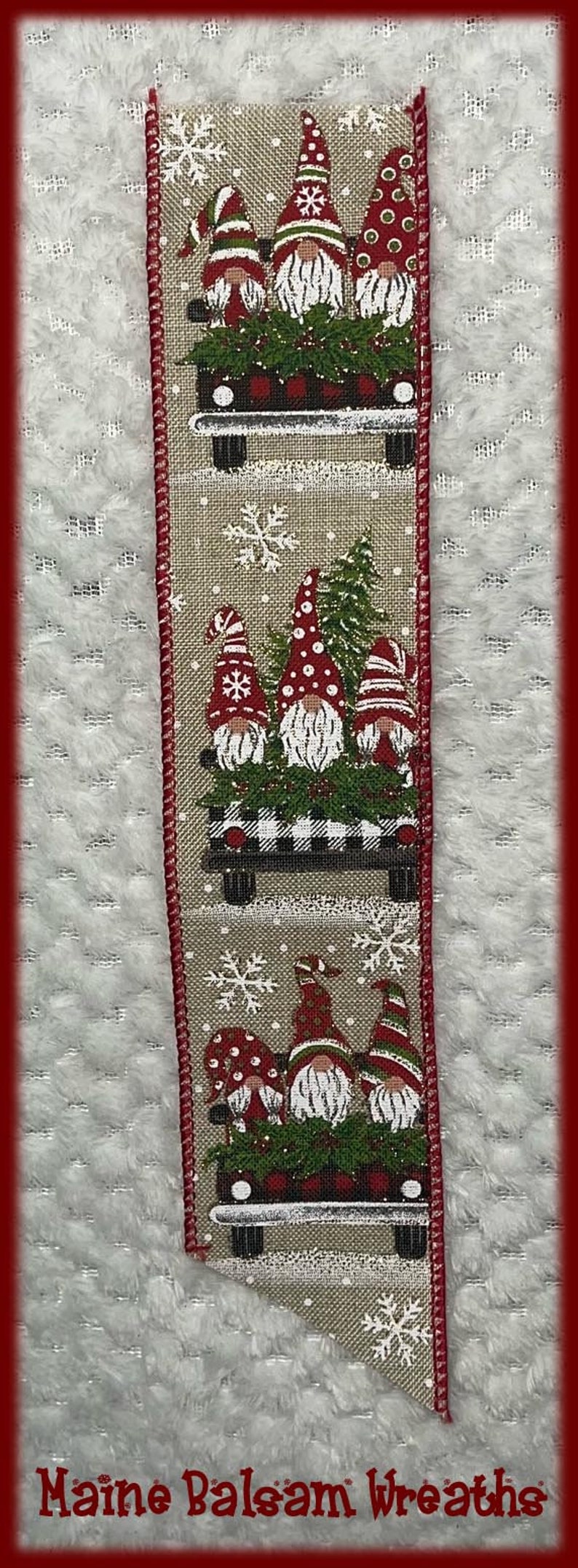 May include: Decorative ribbon featuring gnomes in red hats riding in a truck bed filled with greenery and a buffalo plaid pattern. Snowflakes and the text "Maine Balsam Wreaths" are also present.