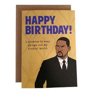 May include: A birthday card with a gold background and the words "HAPPY BIRTHDAY!" in blue. The card features an illustration of a man in a black suit with the text "I promise to keep ya age out my fuckin' mouth."