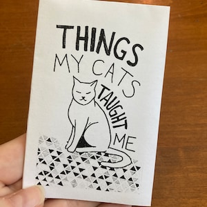 Puede incluir: Una ilustración en blanco y negro de un gato sentado sobre un fondo estampado. El texto "Things My Cats Taught Me" está escrito encima del gato.