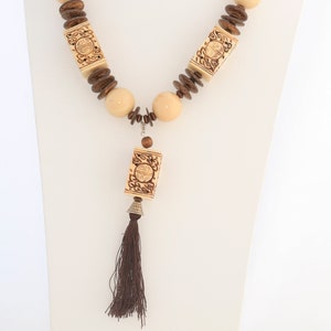 long rope of carved bone beads and round bone beads with a silk tassel