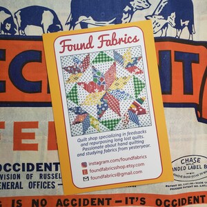 May include: A business card for Found Fabrics, a quilt shop specializing in feedsacks and repurposing long lost quilts. The card features a colorful patchwork quilt design and includes contact information for Instagram, Etsy, and email.