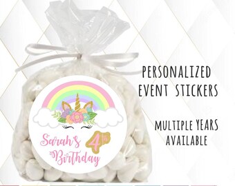 May include: A white circle sticker with a rainbow, unicorn, and clouds. The text "Sarah's 4th Birthday" is on the sticker. The sticker is on a clear plastic bag filled with white candy.
