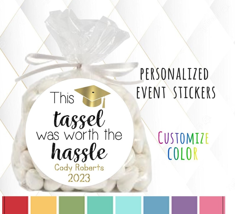 May include: White favor bags with round personalized stickers that say "This tassel was worth the hassle" with a graduation cap graphic and the text "Cody Roberts 2023".