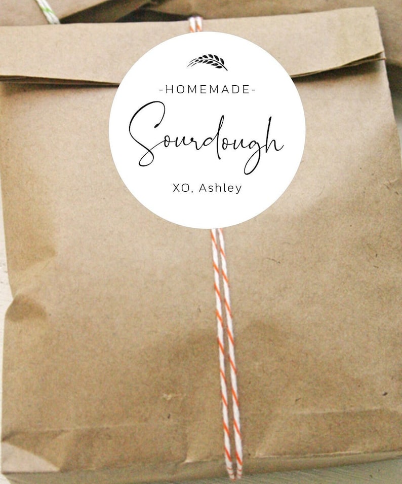 May include: A brown paper bag with a white circle sticker that says "Homemade Sourdough XO, Ashley" with a wheat stalk graphic.