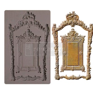 May include: A silicone mold for making decorative cake toppers or other crafts. The mold is shaped like a large ornate picture frame with a smaller picture frame inside. The mold is gray and has a smooth surface.